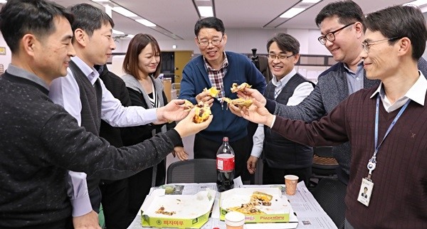 새해 예산안과 세제개편안이 통과된 6일 오후 정부세종청사에서 기획재정부 직원들이 문재인 대통령이 보내온 피자를 맛보고 있다.