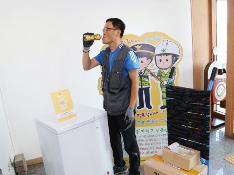 배송업무중 얼음음료로 열기를 식히는 택배기사